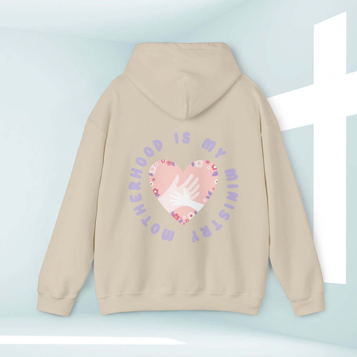 Beige "Motherhood Is My Ministry" Christian hoodie with heart and hand design, perfect gift for homeschooling moms and new mothers.