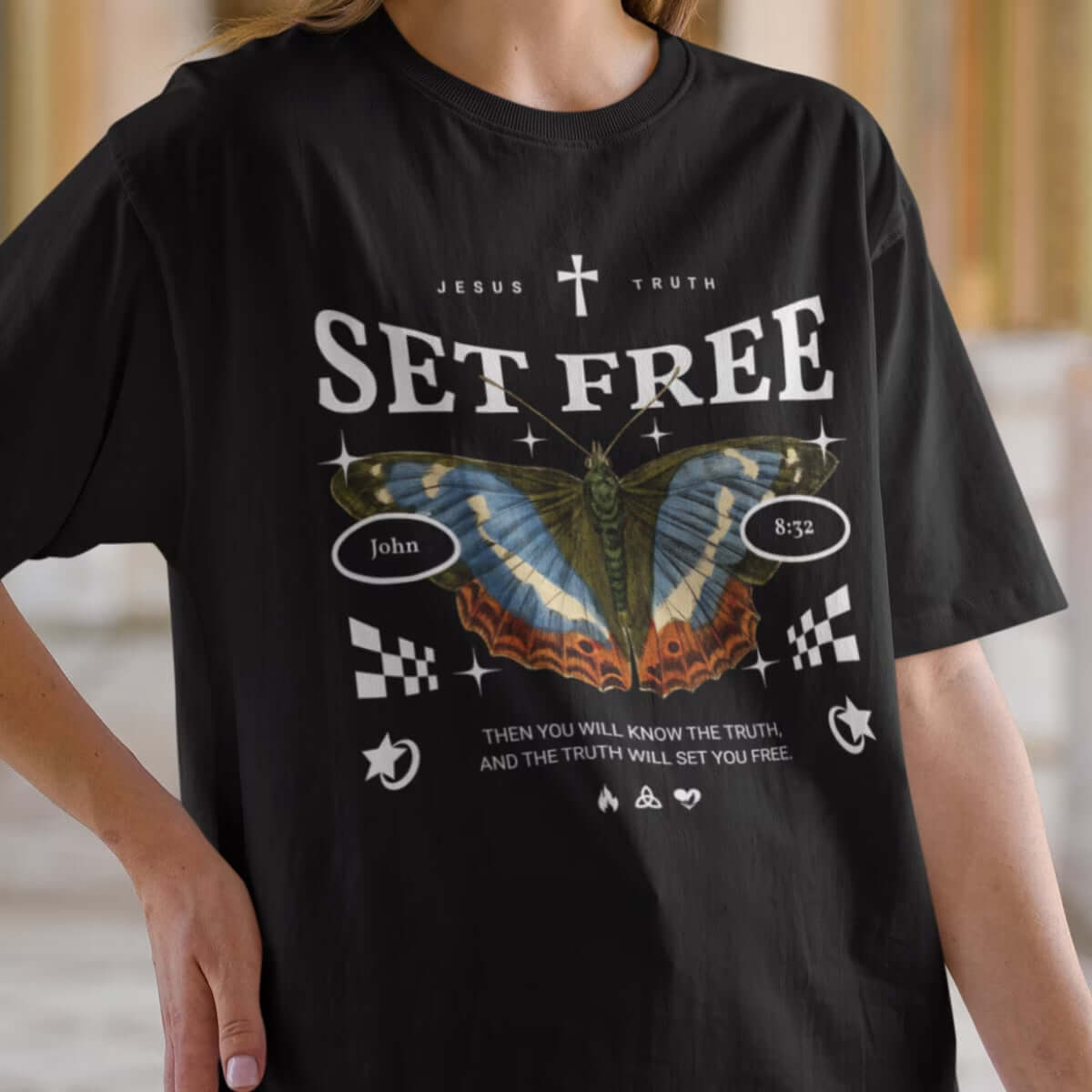 Woman wearing Butterfly Set Free Christian TShirt with Bible verse design, featuring butterfly and religious motifs.