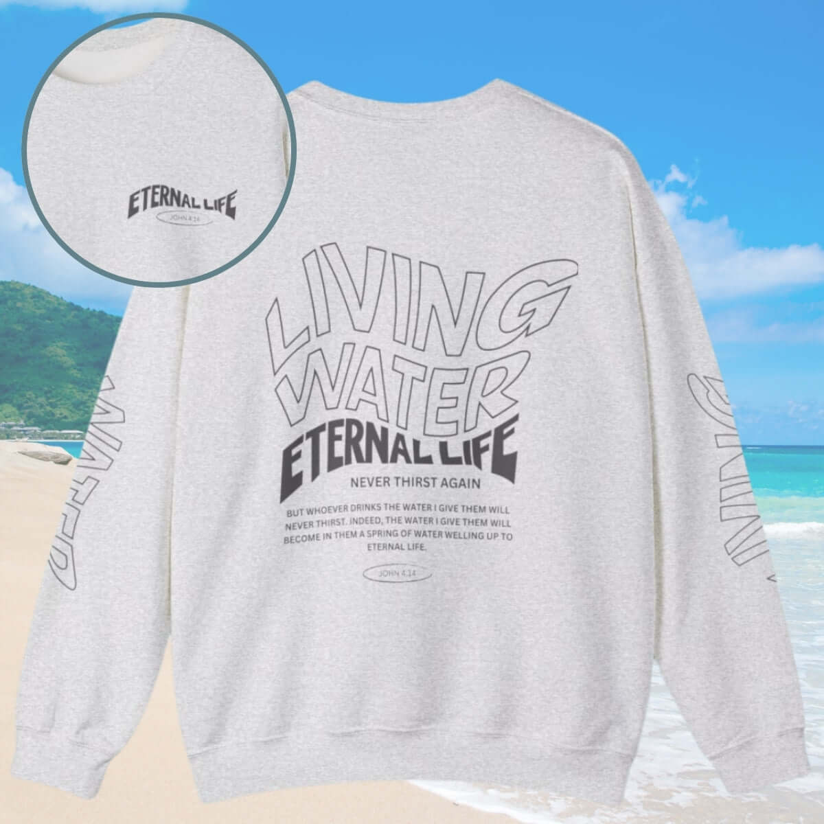 Living Water Eternal Life Christian Sweatshirt with designs on sleeves, front, and back, showcased on a beach background