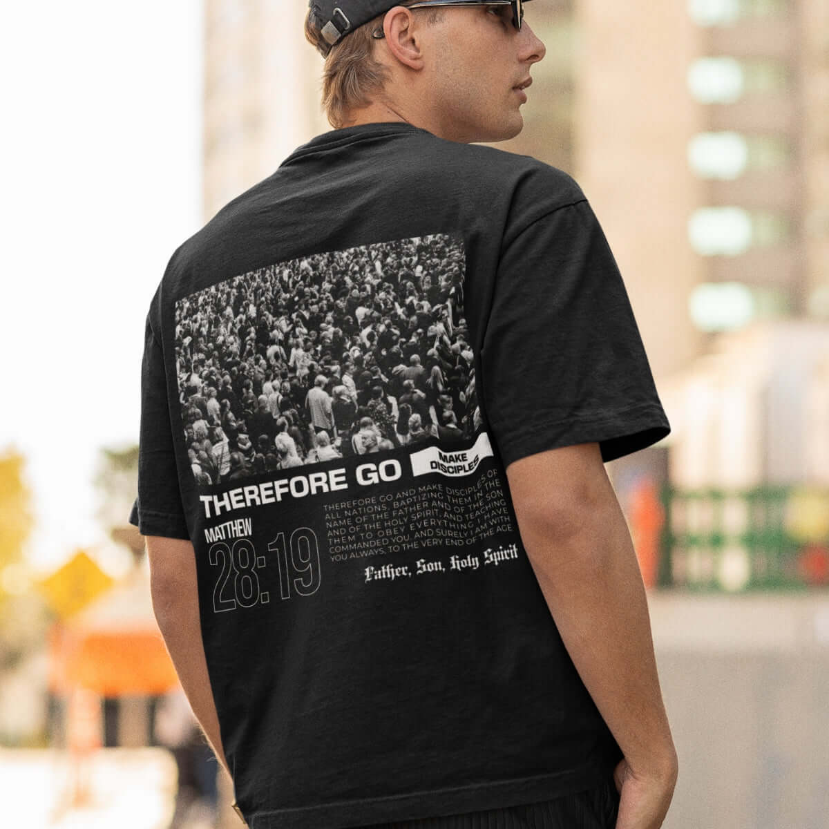 Person wearing "Therefore Go And Make Disciples" Christian t-shirt with Bible verse design in urban setting.