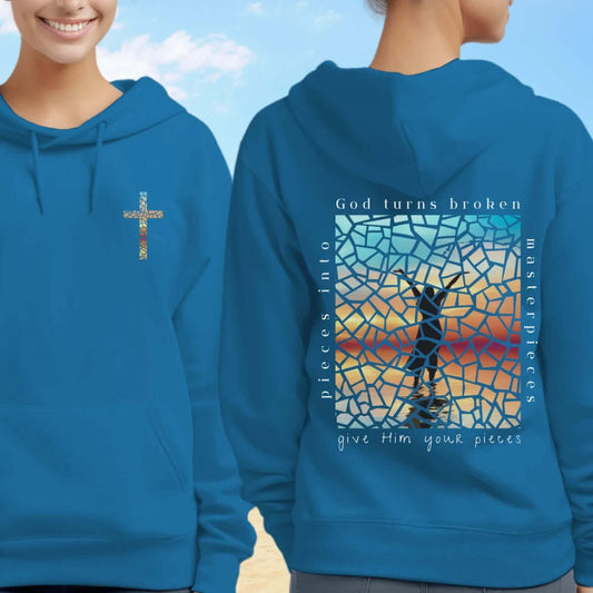 Two people wearing "God Turns Broken Pieces Into Masterpieces" Christian hoodies, showcasing front and back graphics with Bible verse.