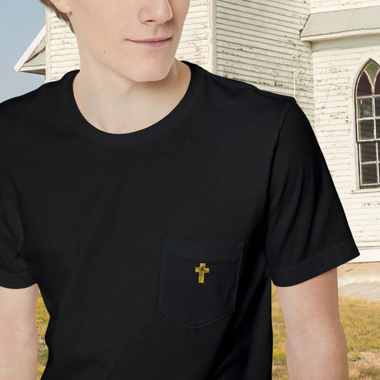 Man wearing a black Gold Cross Pocket Christian T-Shirt standing in front of a church, showcasing men's religious faith-based apparel.