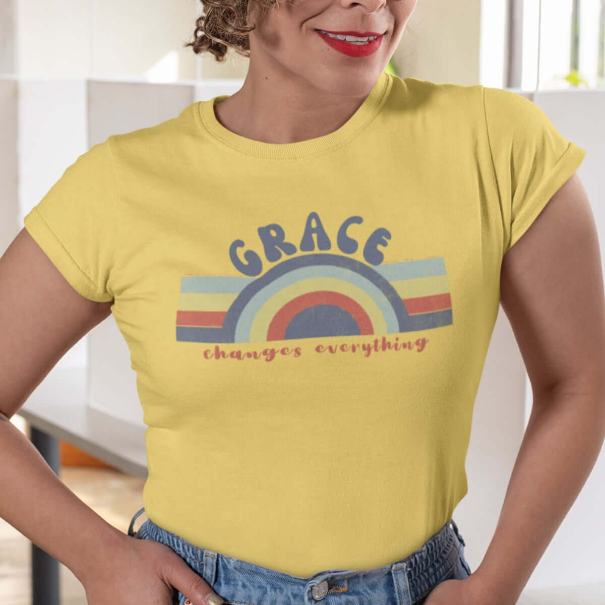 Woman wearing Retro Grace Changes Everything Women's Christian T-Shirt in yellow, featuring faith-based graphic and uplifting message.