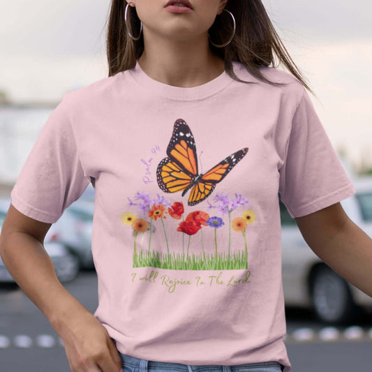 Woman wearing pink I Will Rejoice In The Lord butterfly floral flower Christian t-shirt outdoors.