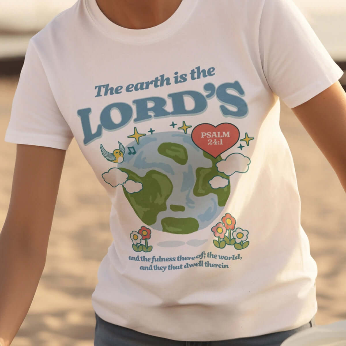 Woman in white camping nature shirt with "The Earth is the Lord's" Bible verse for Earth Day and faith-based inspiration.