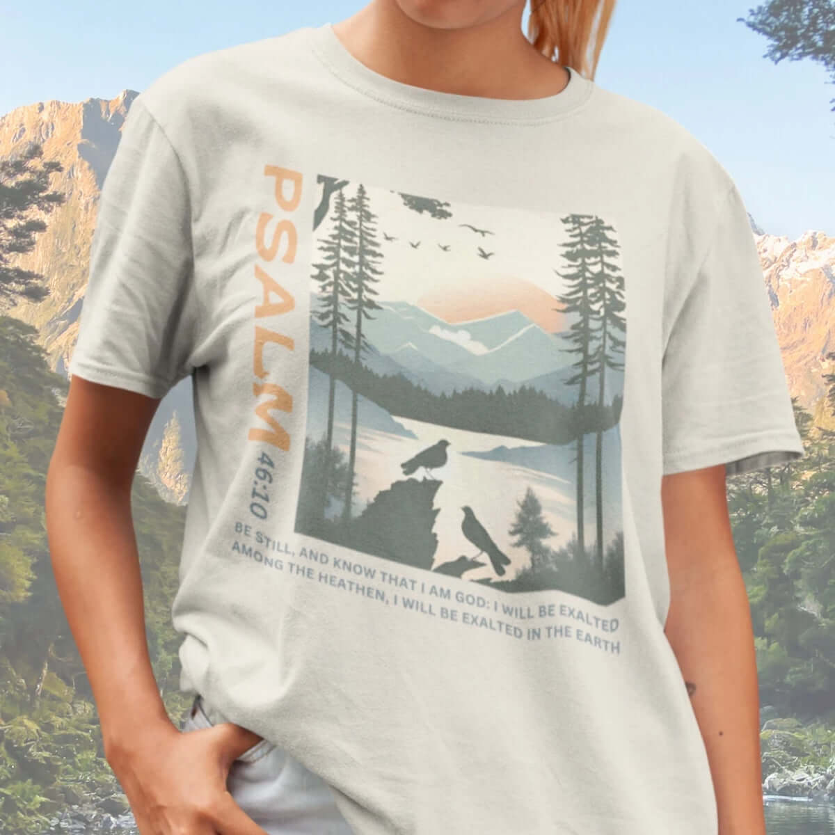 Woman wearing Peace Be Still Birds Christian T-shirt with Psalm 46:10 scripture in nature background.