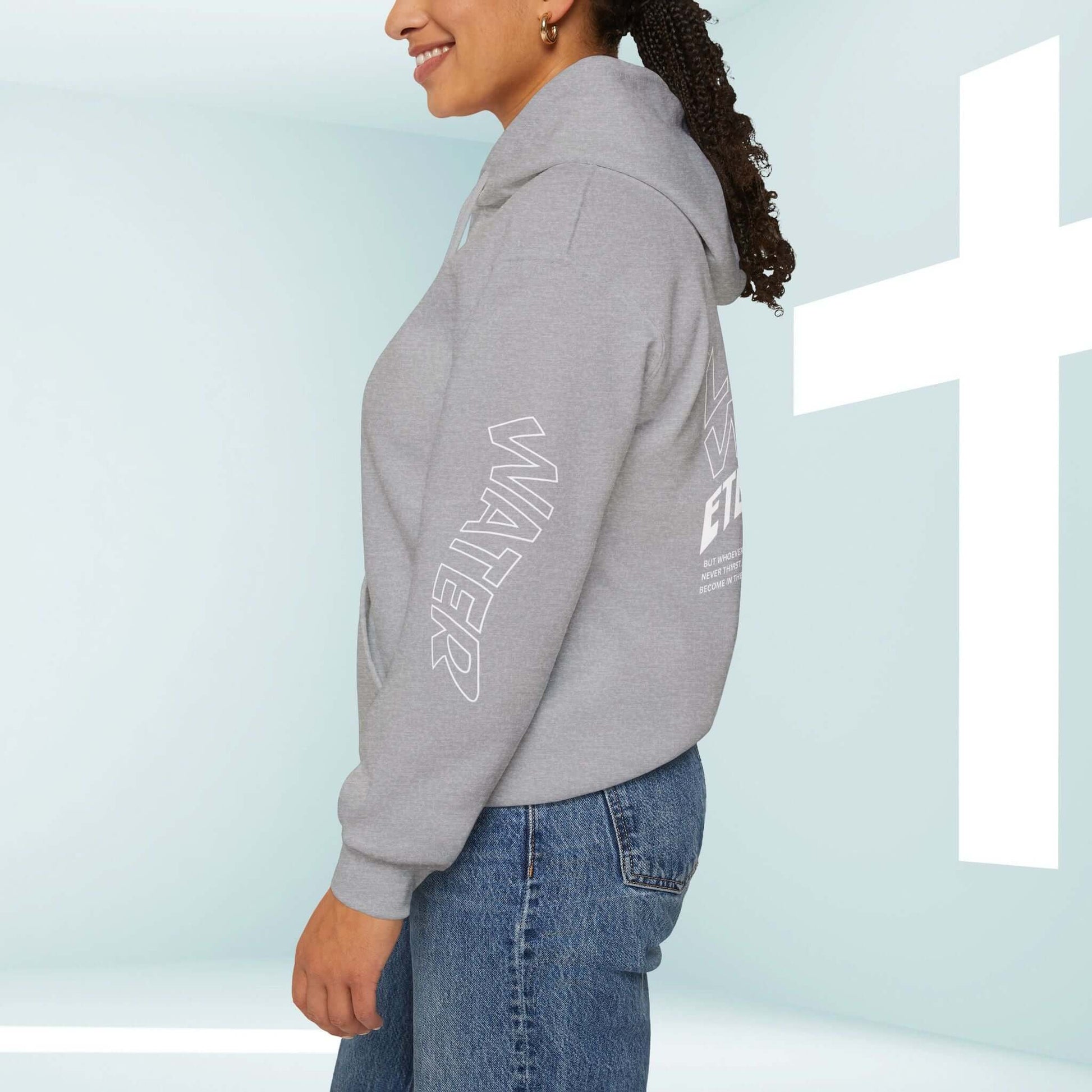 Woman wearing Living Water Christian hoodie with bible verse graphics on sleeves, front, and back in a church setting.