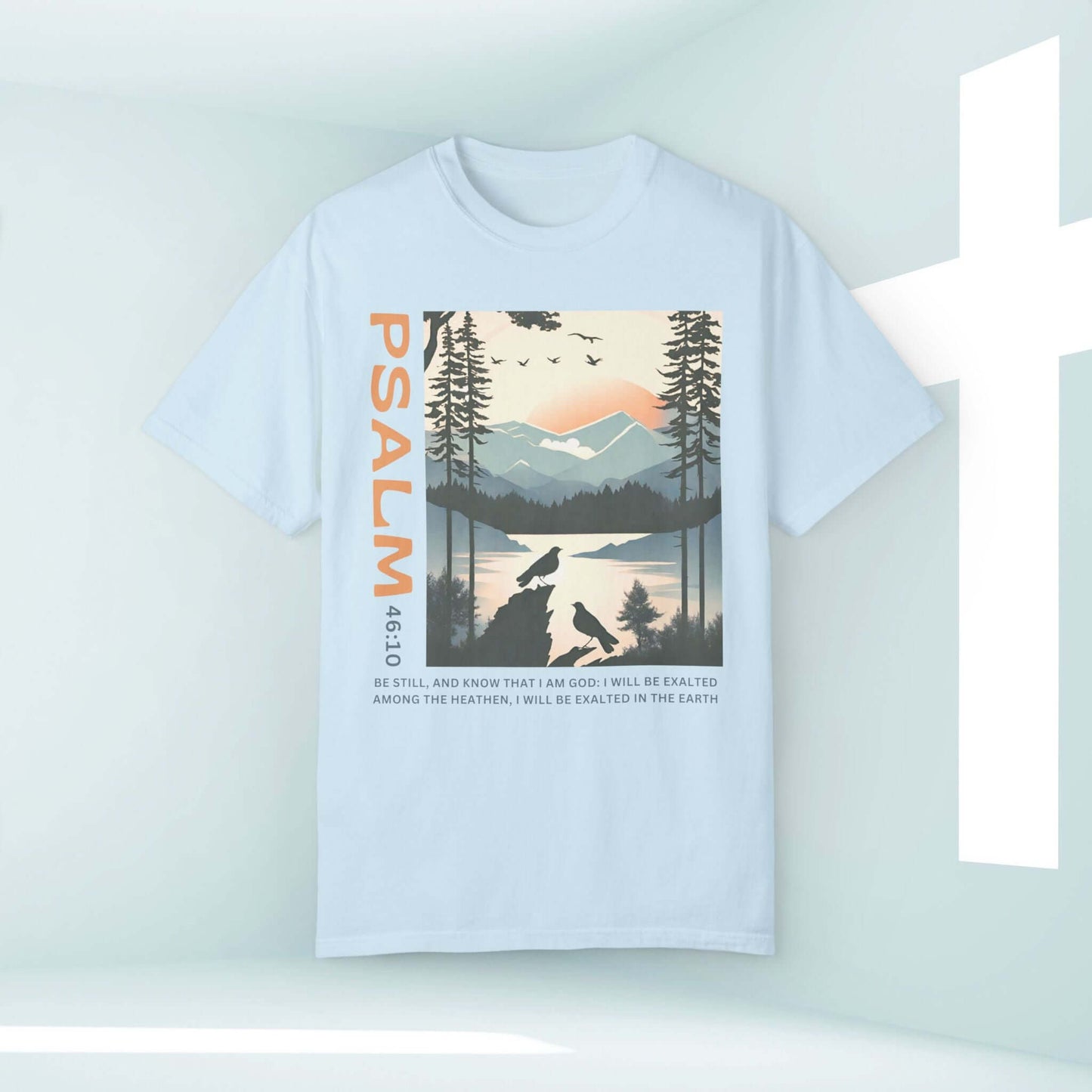 Peace Be Still Birds Christian T-Shirt featuring Psalm 46:10 with scenic bird and nature graphic in soft pastel hues. Inspirational Christian apparel.