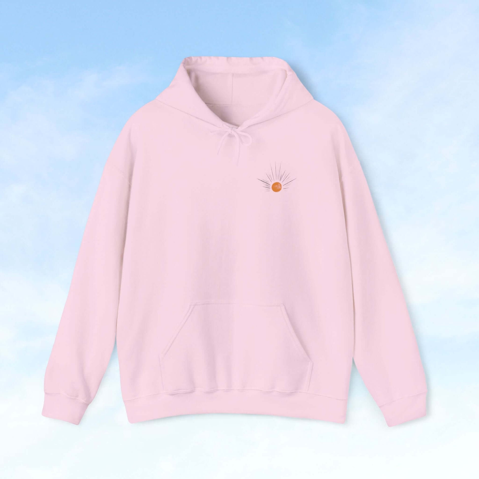 Be The Light Sunburst Christian hoodie with celestial sun ray design on pale pink background, perfect Christian gift and faith-based apparel.