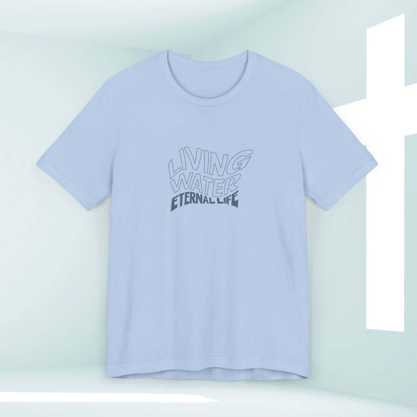 Light blue Living Water Eternal Life T-Shirt with faith-based graphic in a minimalist room with a white cross.