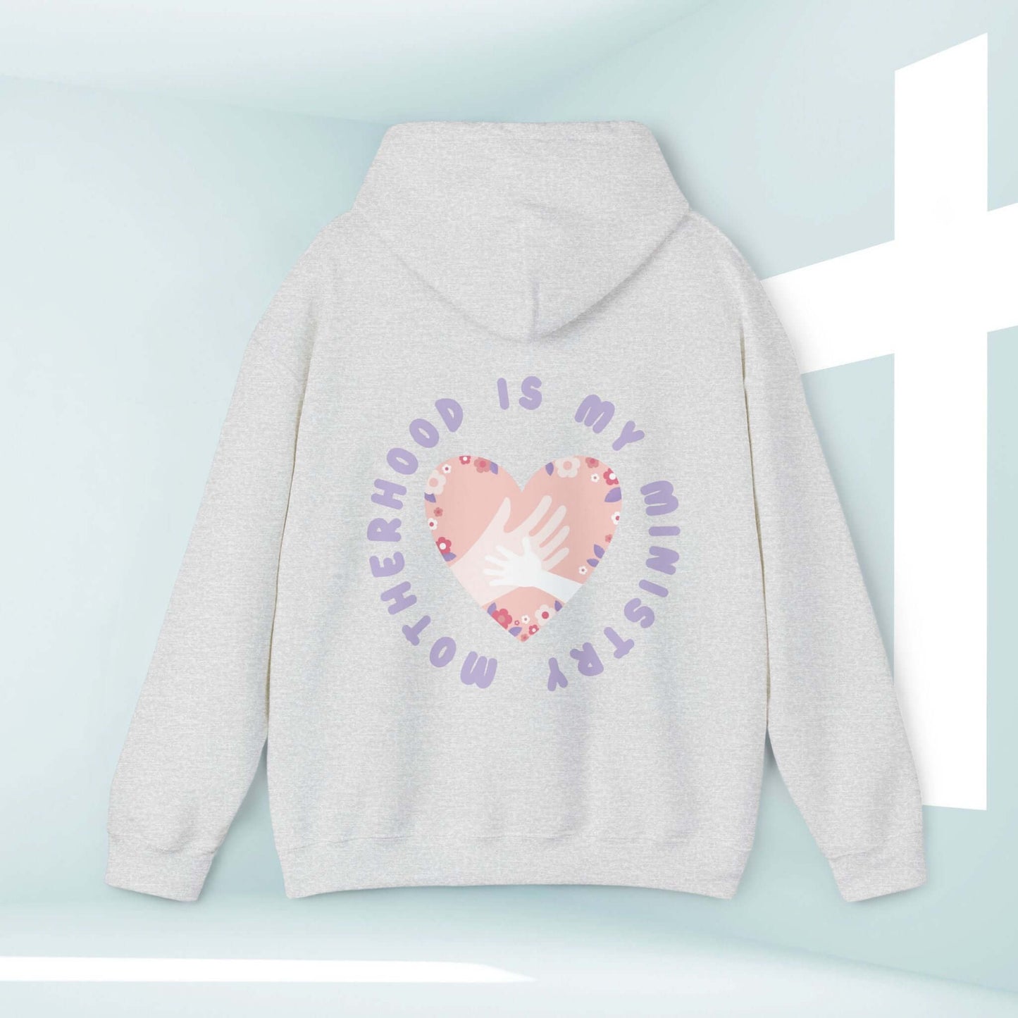 Motherhood Is My Ministry Christian hoodie with heart and hand design on back, perfect gift for new moms and homeschoolers.