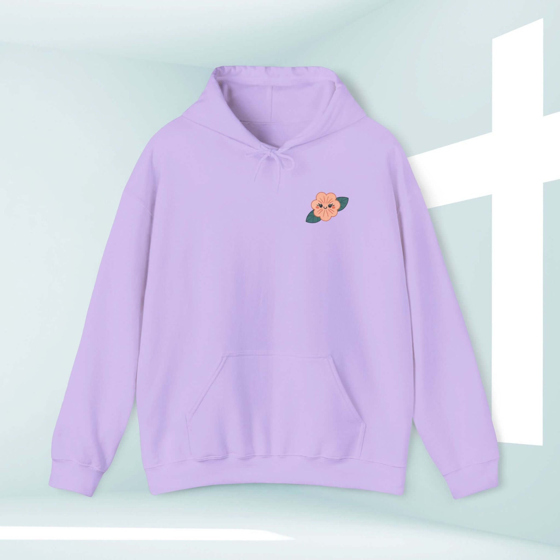 Light purple Christian hoodie with floral design by a white cross, blending comfort with faith, perfect for cooler beach days and inspirational style.