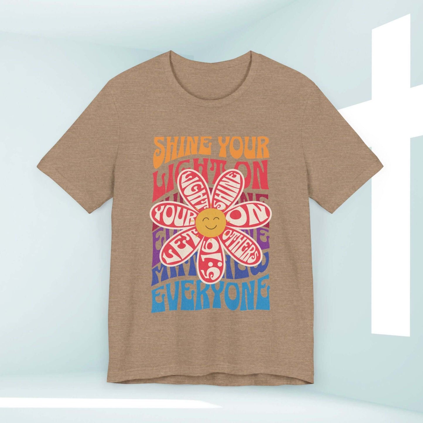 Shine Your Light Christian t-shirt with a retro flower graphic and inspirational message on beige cotton fabric, perfect for church and bible study