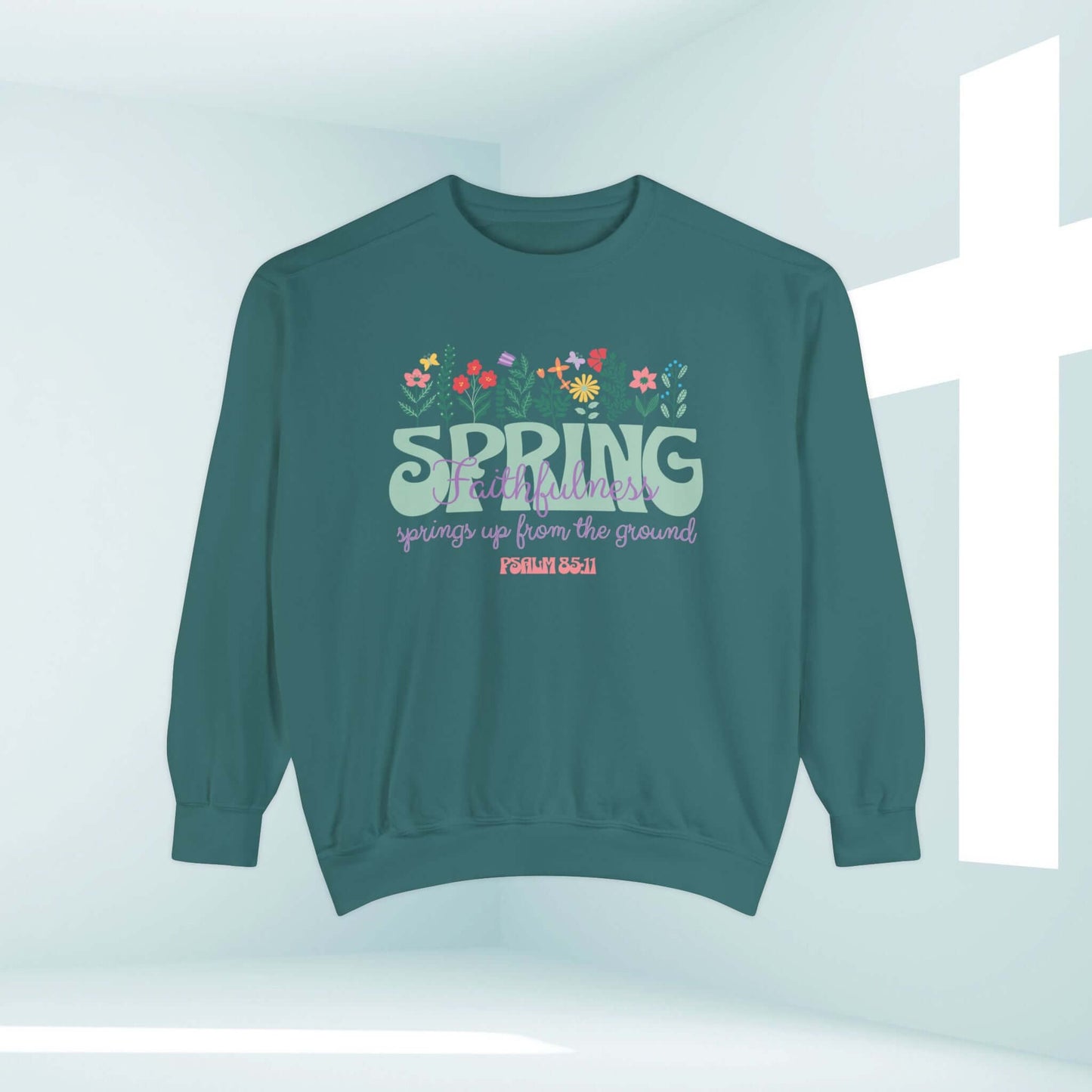 Inspirational floral spring shirt with Bible verse on green Christian sweatshirt in front of cross.