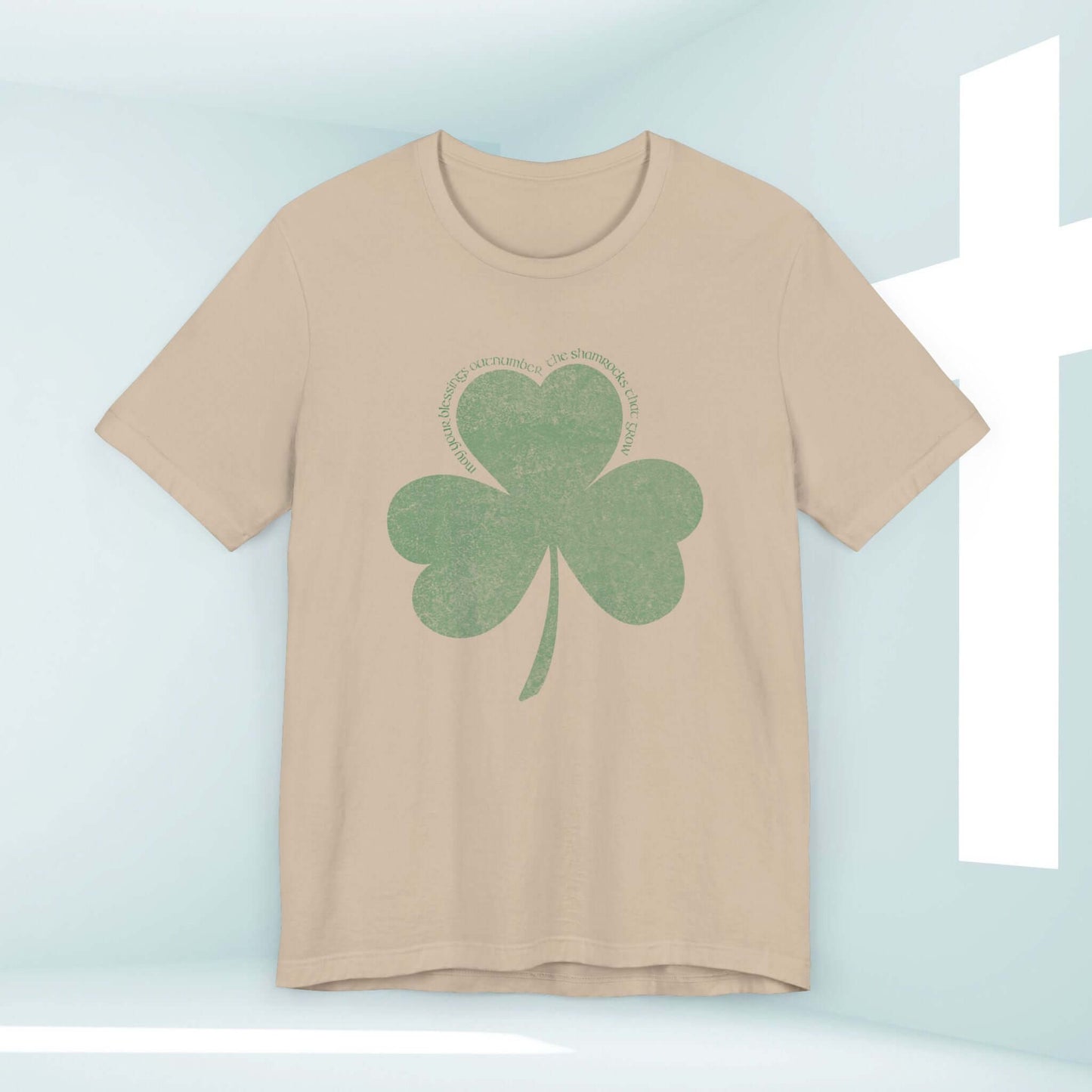 Christian St Patrick's Day shirt with shamrock clover design on beige background, inspiring faith and blessings.