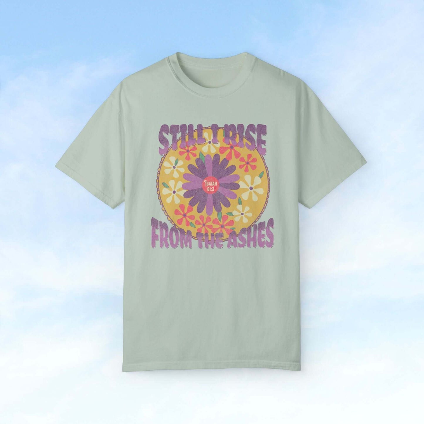 "Still I Rise From The Ashes Christian flower shirt with colorful floral design against a sky background"