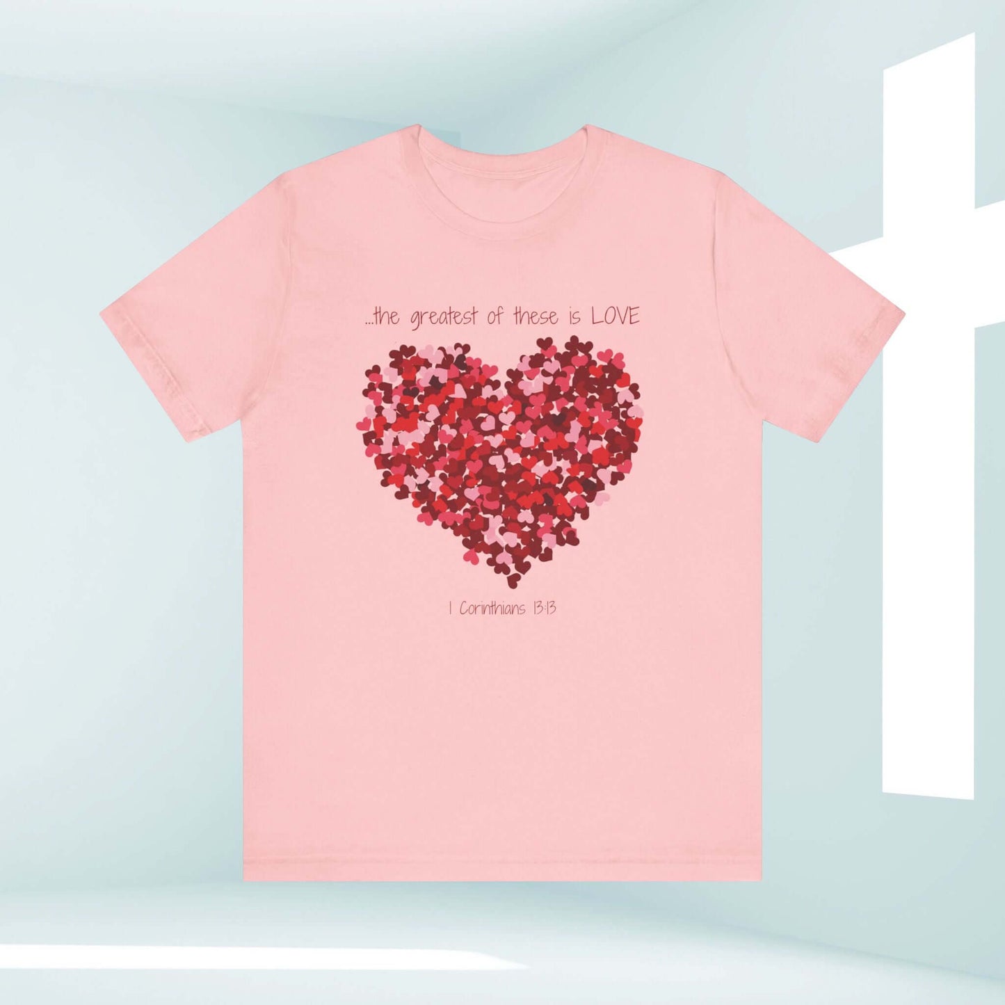 Pink Christian Valentine's Day t-shirt with heart graphic and "the greatest of these is love" text, perfect wedding or anniversary gift