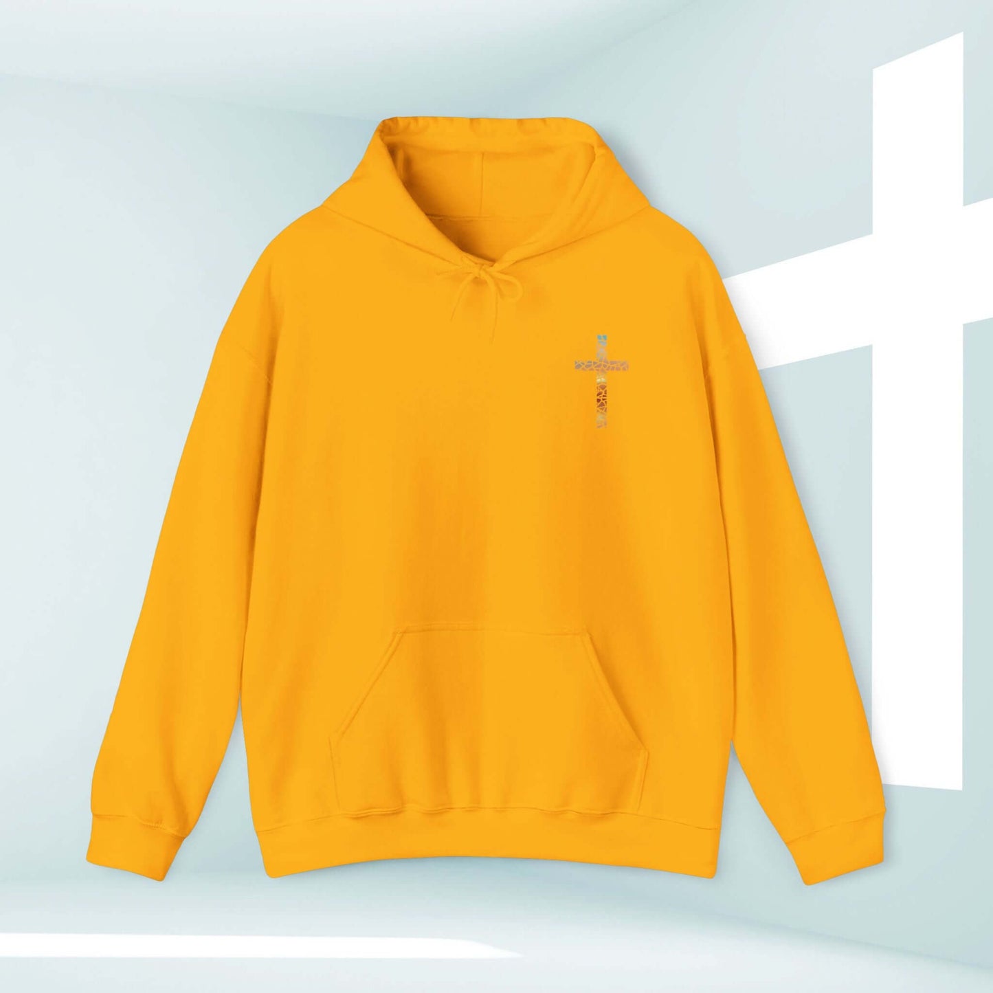 God Turns Broken Pieces Into Masterpieces Christian hoodie in mustard yellow with front cross graphic in a modern worship background