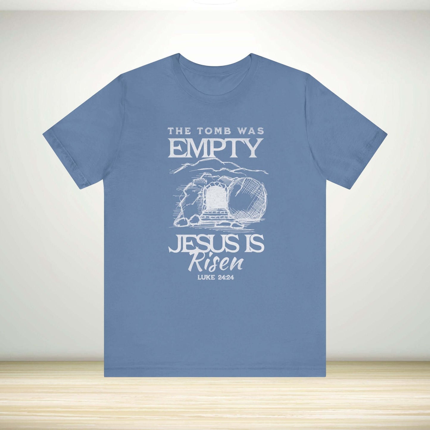 Blue Christian Easter shirt with "The Tomb Was Empty, Jesus Is Risen" design, ideal for religious easter clothing and Christian apparel.