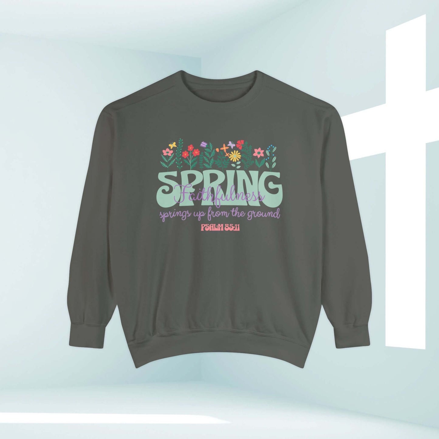 Christian sweatshirt with floral design and Bible verse, "Spring up from the ground," in a church setting.