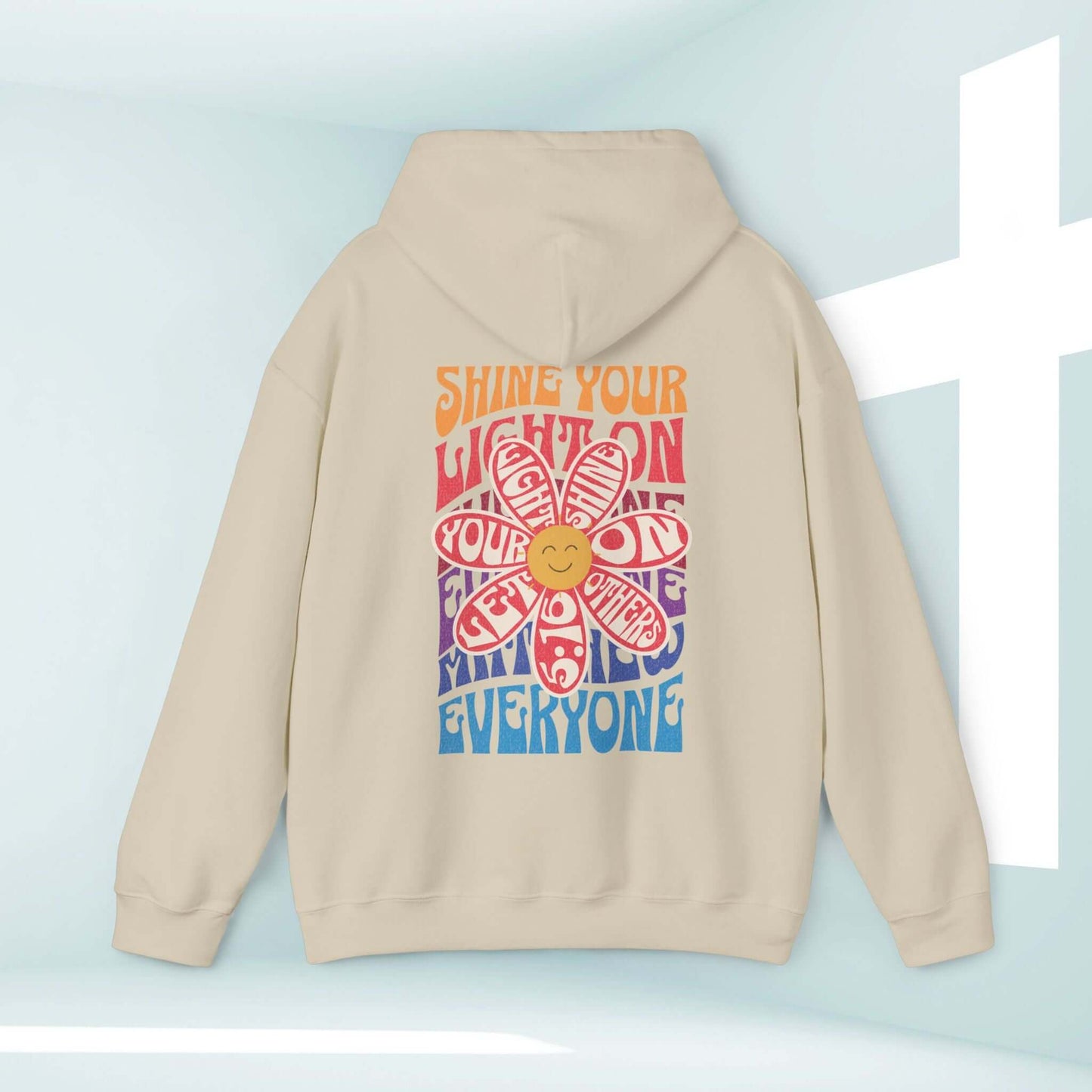 Shine Your Light boho Christian hoodie with inspirational Bible verse, faith-based flower design, and smiley face on beige background