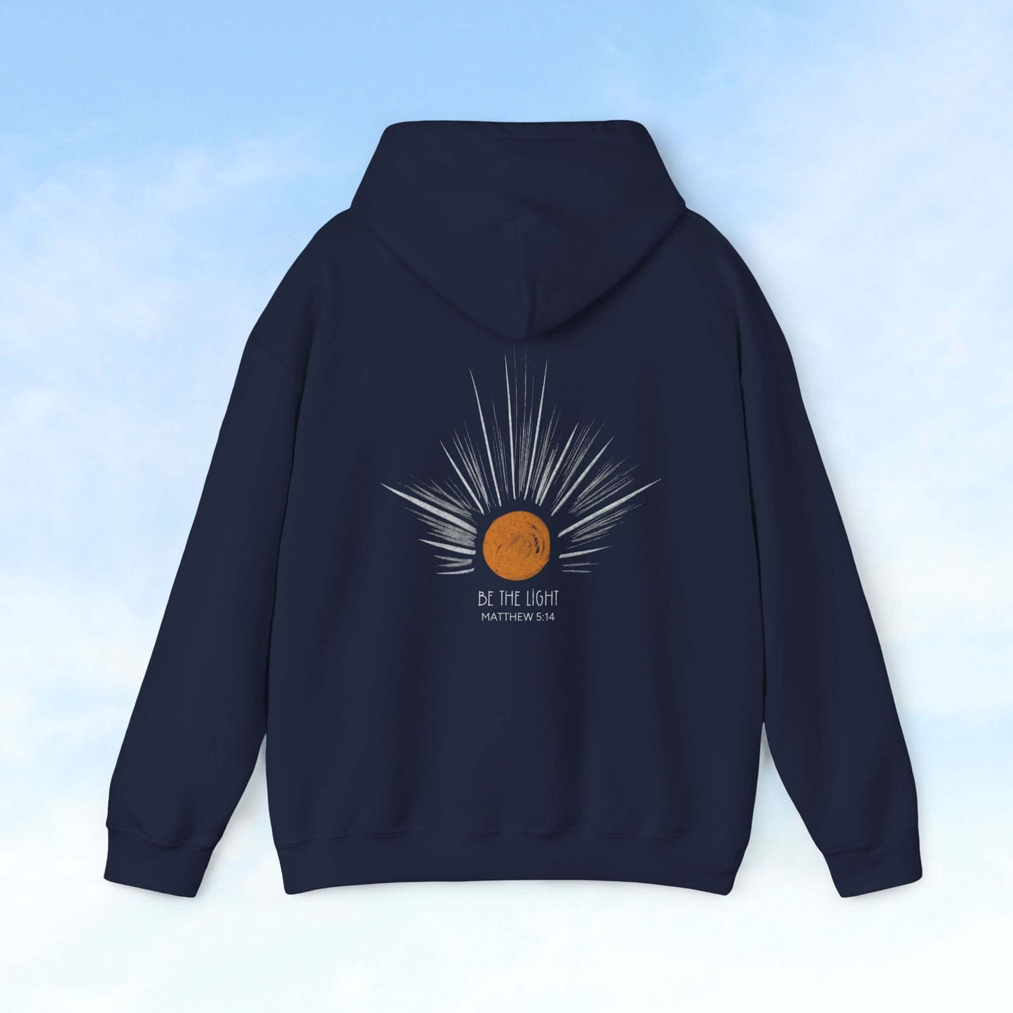 Back view of a navy hoodie with "Be The Light" sunburst graphic, featuring celestial sun rays and Matthew 5:16 Bible verse.