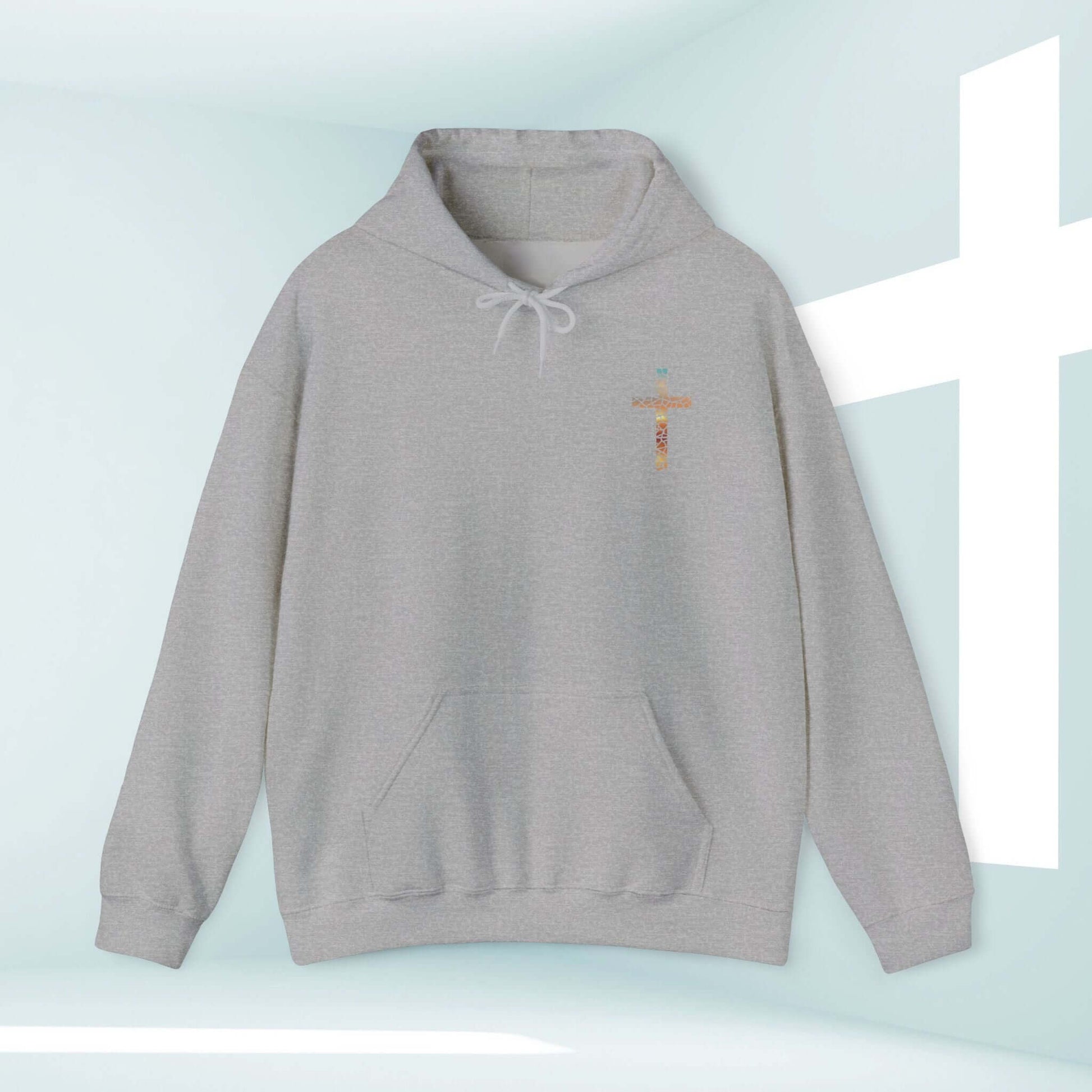 Gray God Turns Broken Pieces Into Masterpieces Christian hoodie with front graphic design against a light background with a cross.