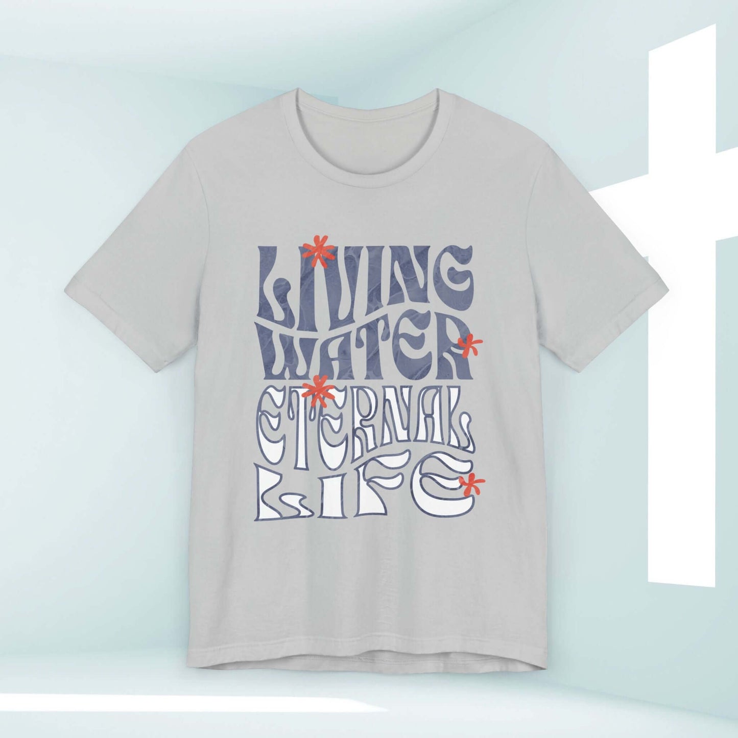 Living Water Faith Elevated Christian T-shirt with "Living Water Eternal Life" design, hung against spiritual white cross backdrop