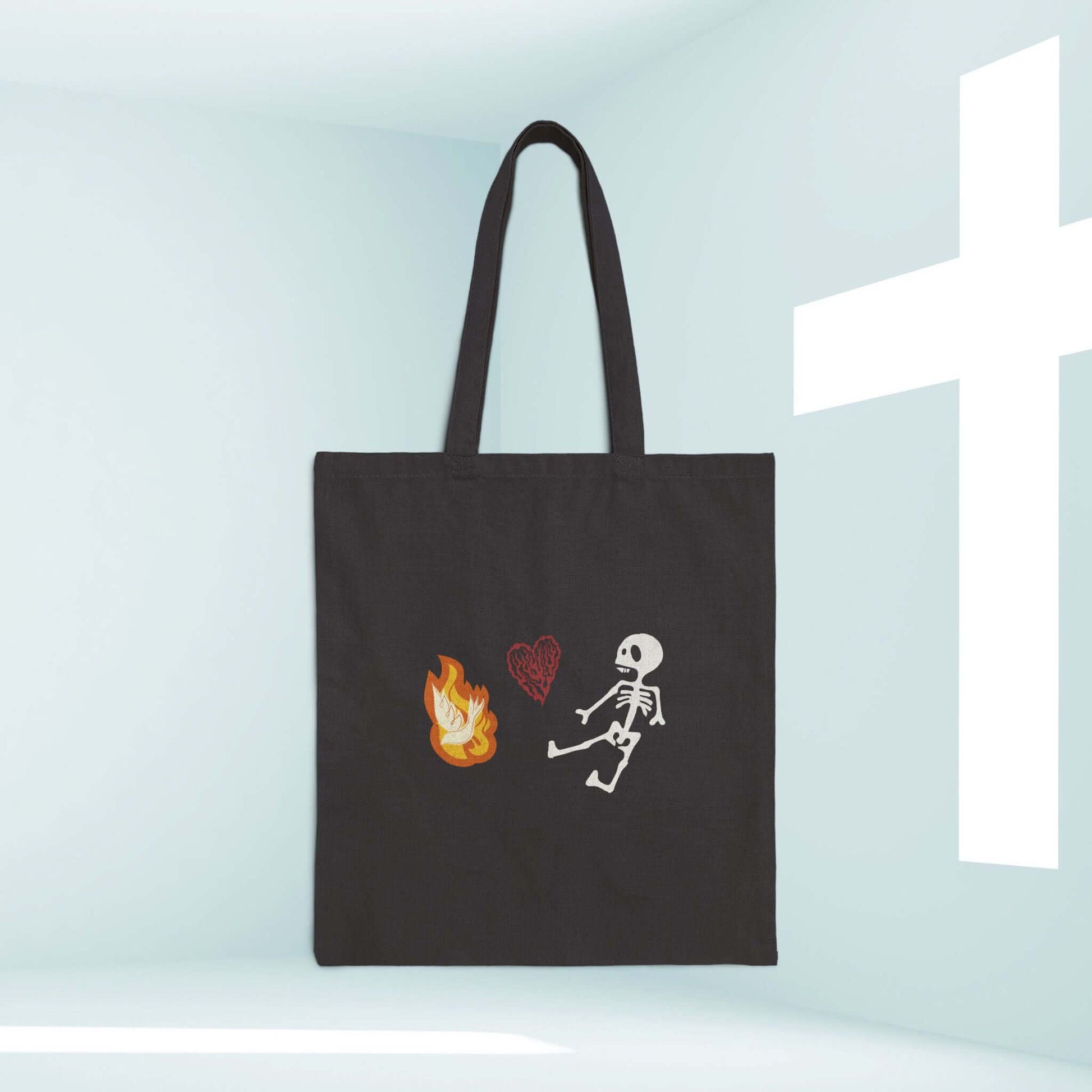 Christian Halloween tote bag with cute skeleton, flame, and heart in a room with a cross. Perfect religious trick or treat bag.