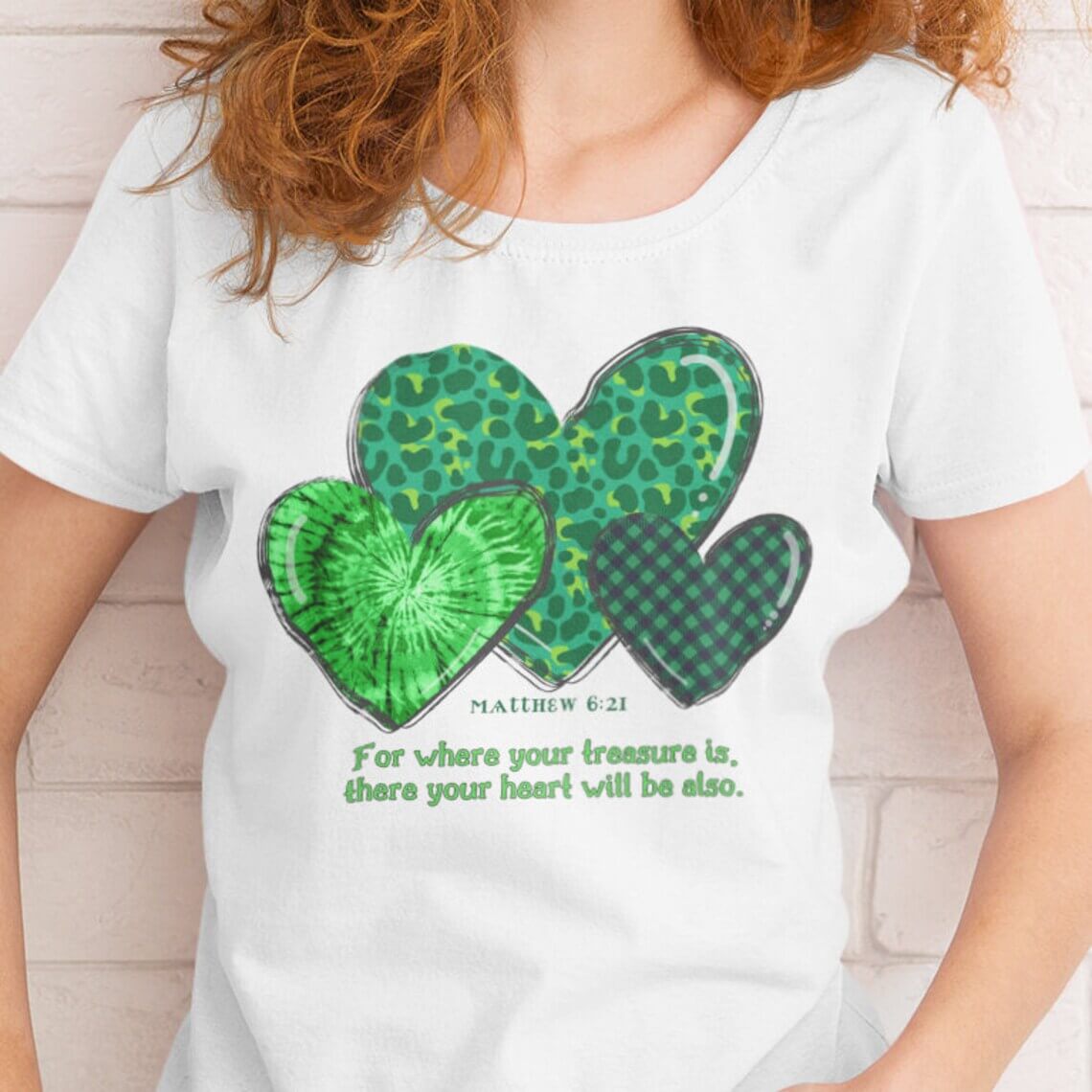 Woman wearing a St Patrick's Day shirt featuring green hearts and Matthew 6:21 Bible verse for Christian inspiration